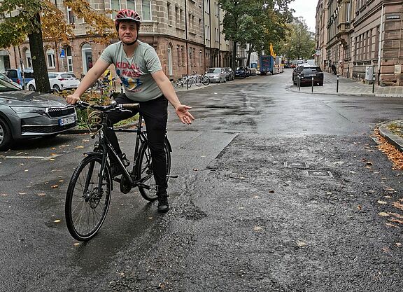 Der Kreisvorsitzende des ADFC Nürnberg zeigt die desolate Oberfläche der Pilotystraße 