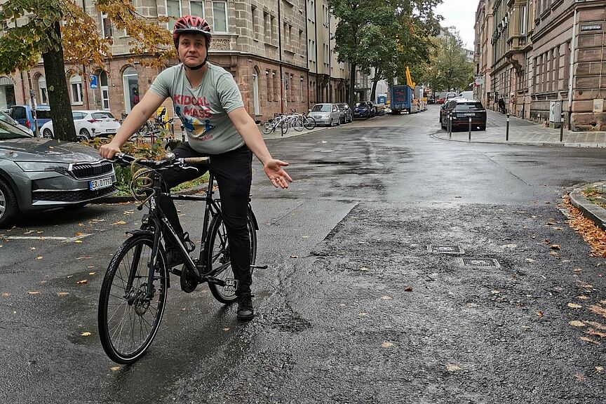Der Kreisvorsitzende des ADFC Nürnberg zeigt die desolate Oberfläche der Pilotystraße